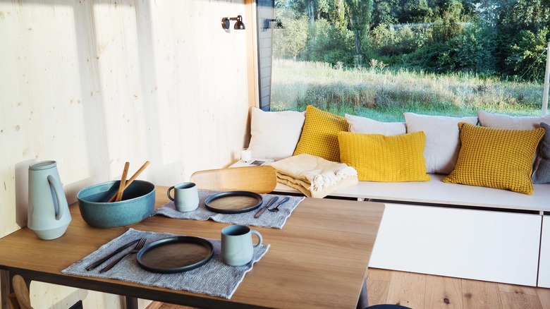 modern tiny house dining area with table and window bench