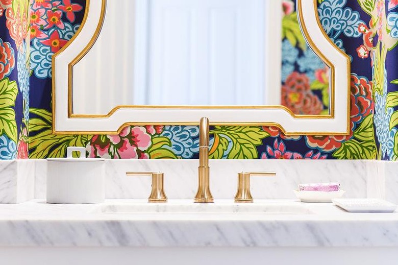 bright modern wallpaper in bathroom with marble sink and gold faucet