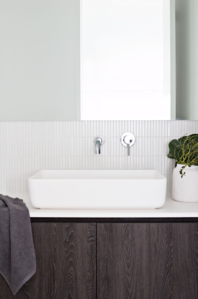 vertical mosaic bathroom backsplash idea in white behind vessel sink