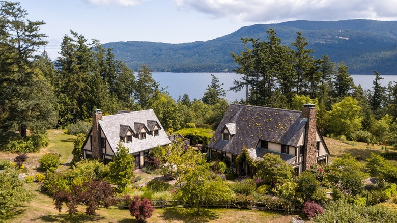 two homes in the woods in front of lake