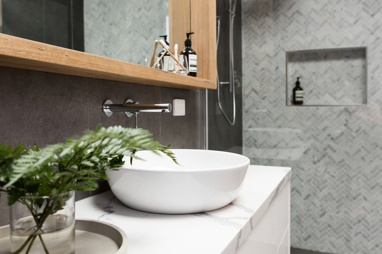 Bathroom details clean white basin with shower tiling behind