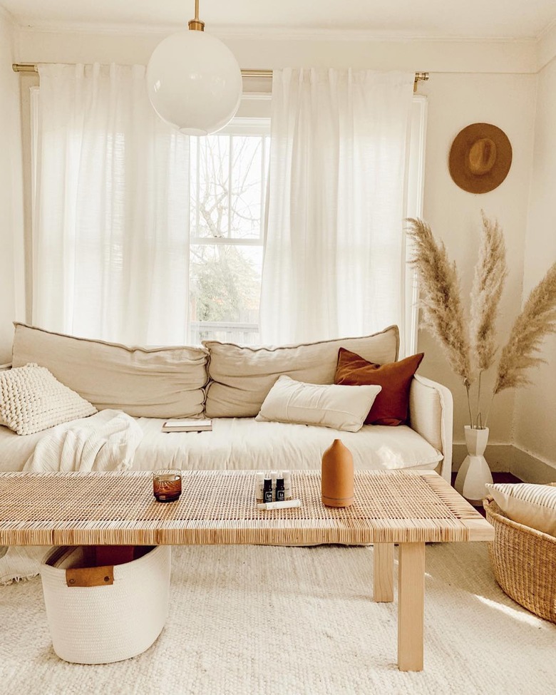 natural decor in cream-colored living room with linen sofa and woven coffee table