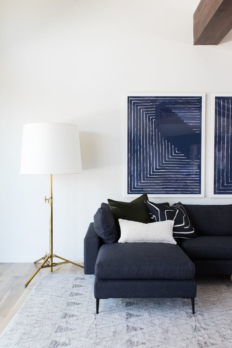 navy blue living room idea designed by Studio Mcgee with blue sofa and artwork