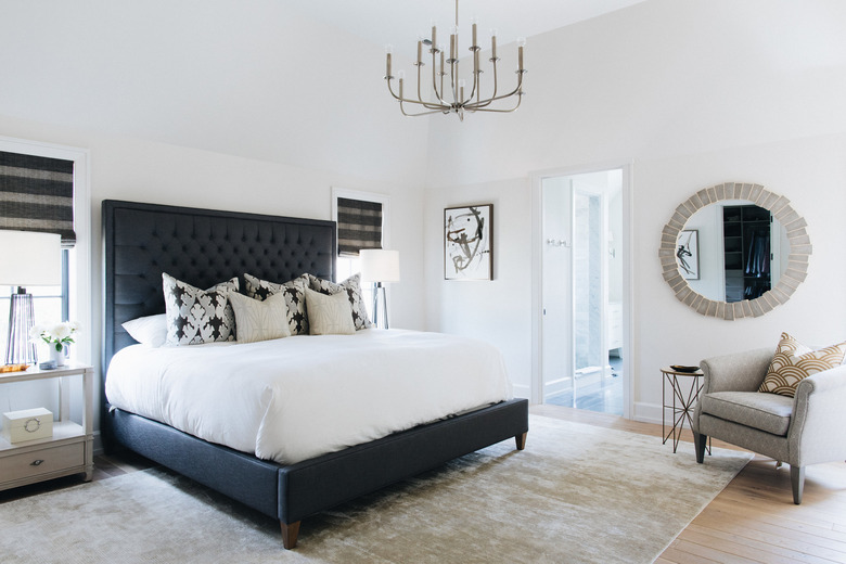 black and white bedroom idea with traditional accents and upholstered headboard