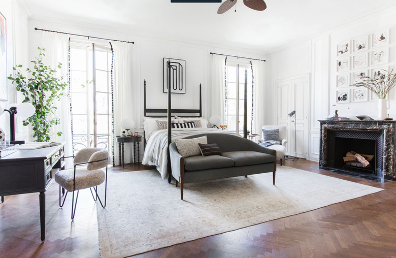 black and white bedroom idea with four poster bed and marble surround fireplace