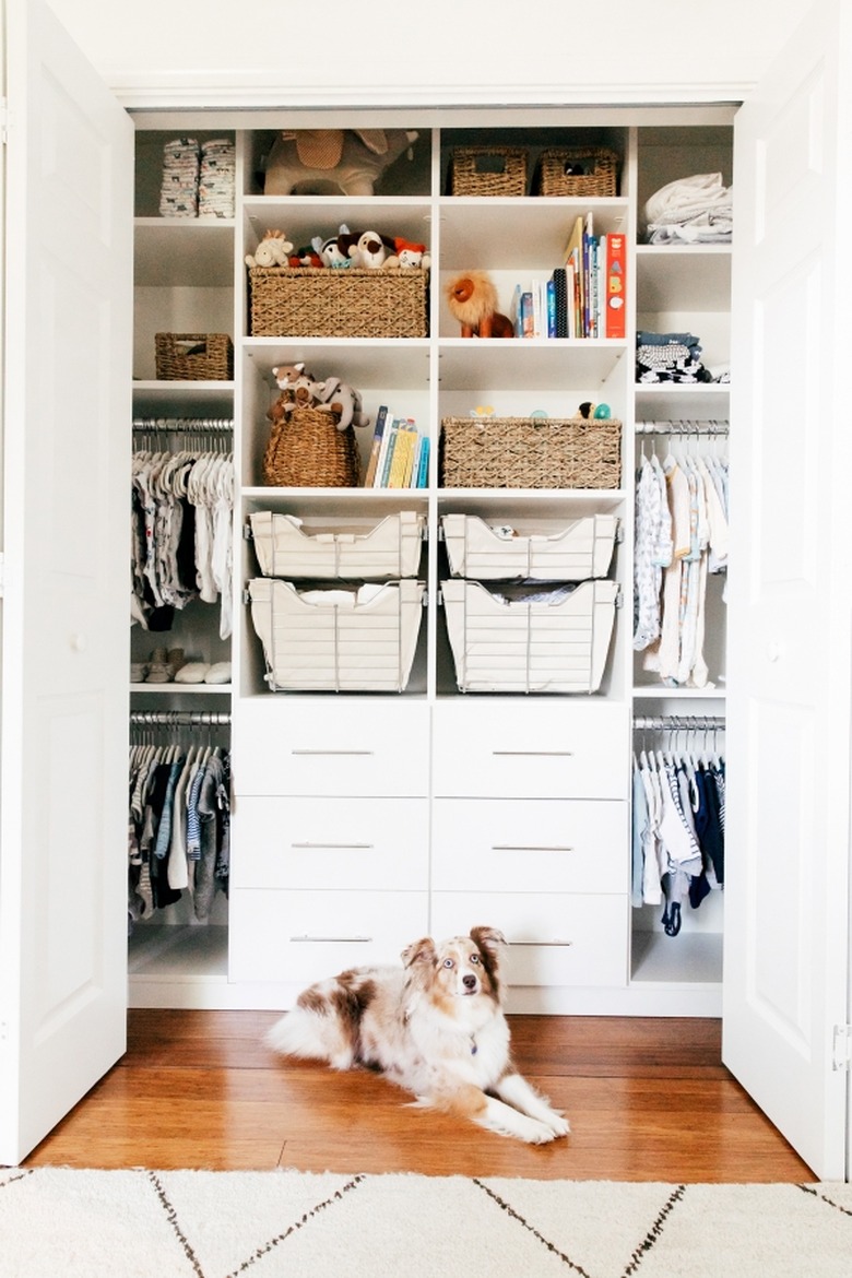 Closet nursery organization with drawers and shelving and rods for clothing