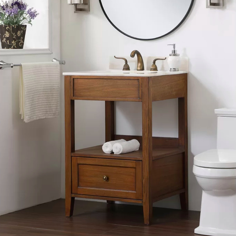 wood bathroom vanity with white toilet nearby