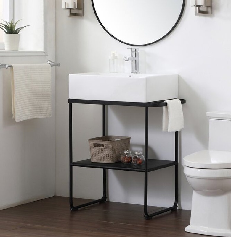 bathroom vanity with white sink and black legs near while toilet