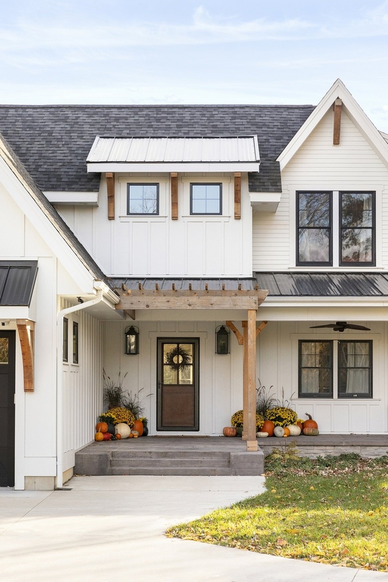 farmhouse with gourds and hay flanking the front door