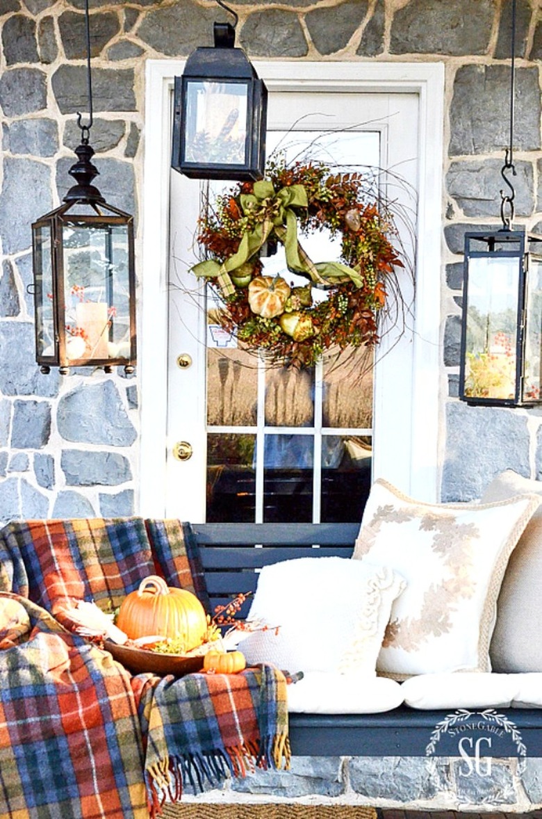 porch with black bench and a plaid throw