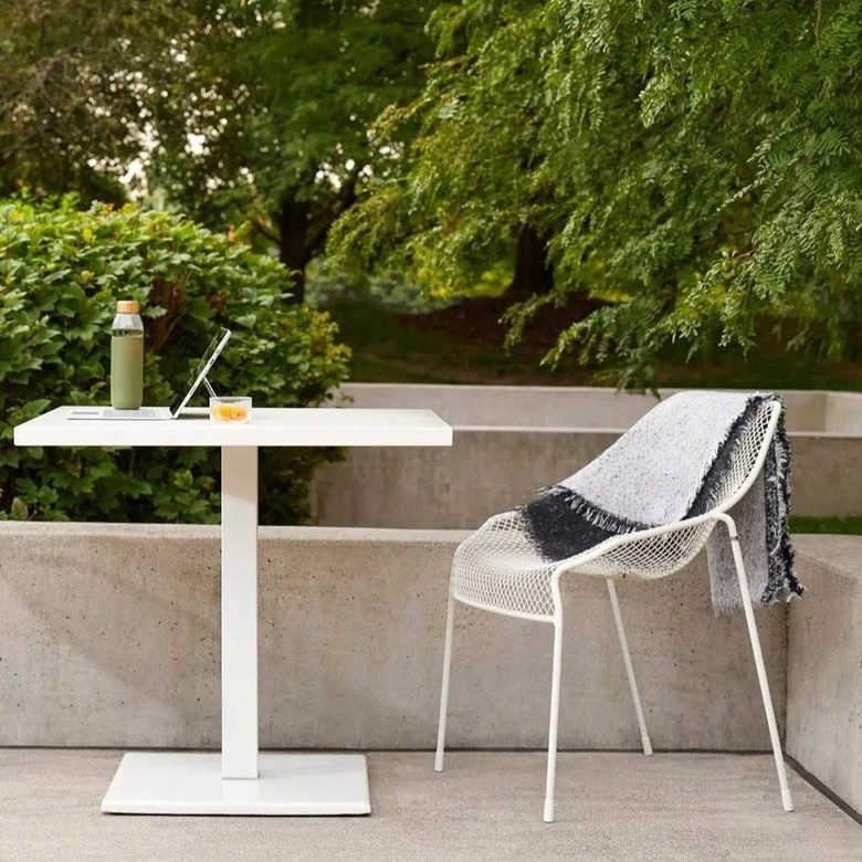 simple white desk and chair outside on concrete patio