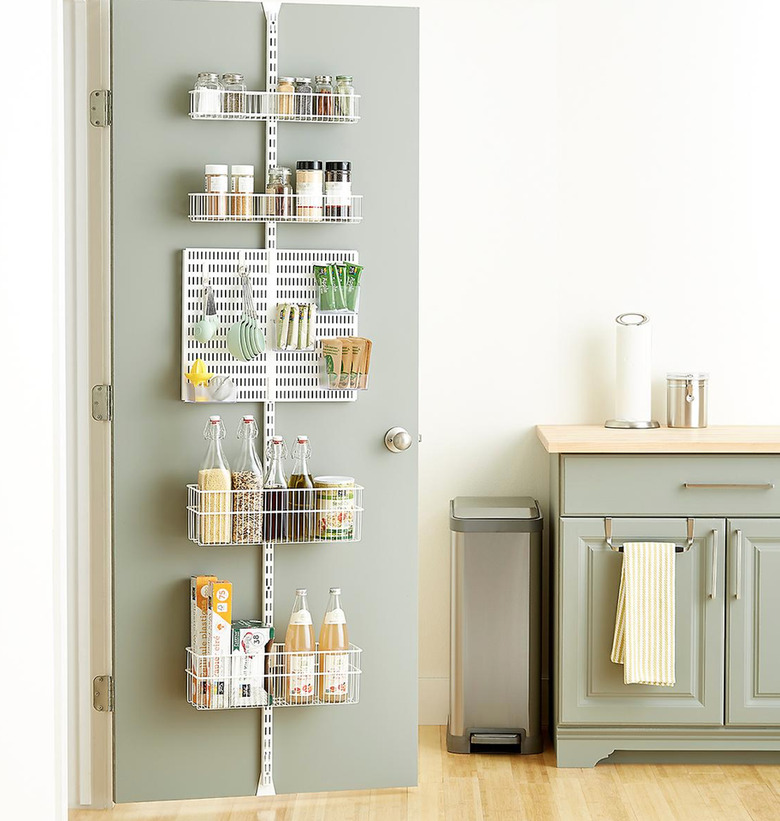 Over the Door Storage with White metal over the door organizer, sage green door and cabinets.