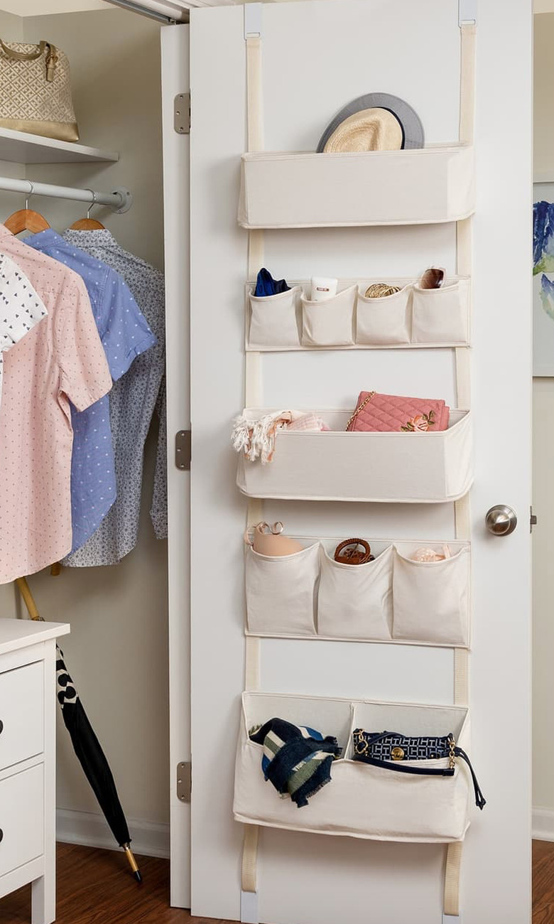 Over the Door Storage with Canvas organizer on door, closet with clothes.