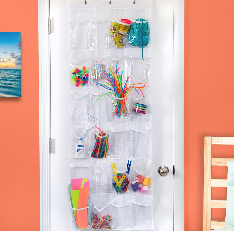 Over the Door Storage in Bedroom with plastic over the door storage, orange walls, toys.