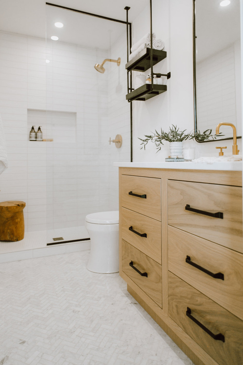 bathroom towel storage idea in white bathroom with walk in shower