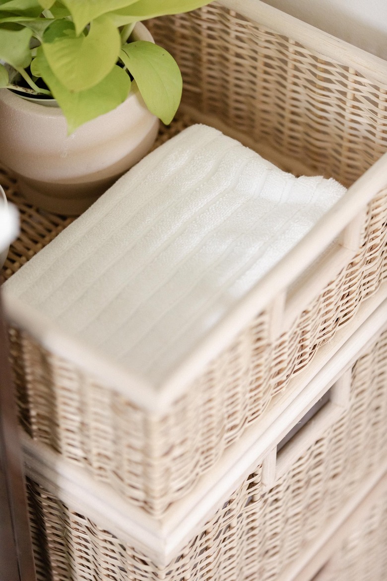 woven baskets and folded white hand towels in bathroom