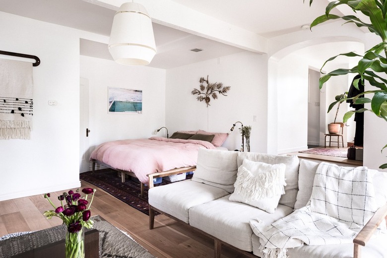 Pink bedspread on bed in bohemian bedroom