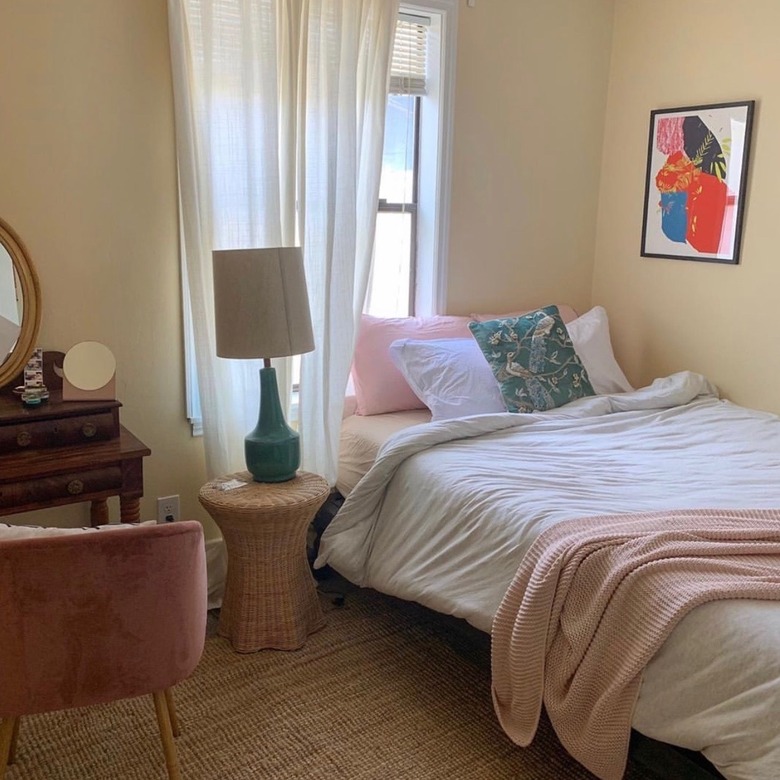 backdrop's mood lighting paint on the walls of a bedroom with a bed, vanity, armchair, and side table