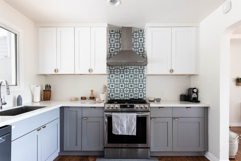 Minimalist kitchen with gray and white cabinets and a green-white tile backsplash