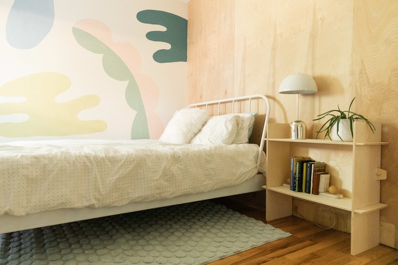 kids bedroom with wood paneling and pastel mural painted on wall