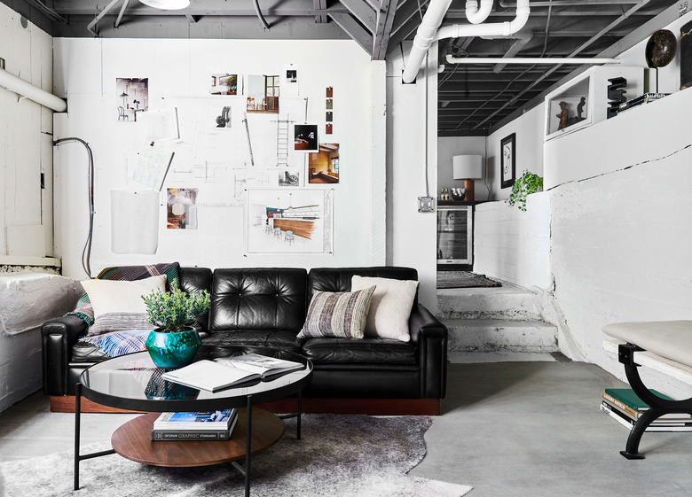 painted basement ceiling with white walls and black couch