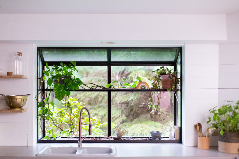 closeup of window above kitchen countertop with shiplap walls