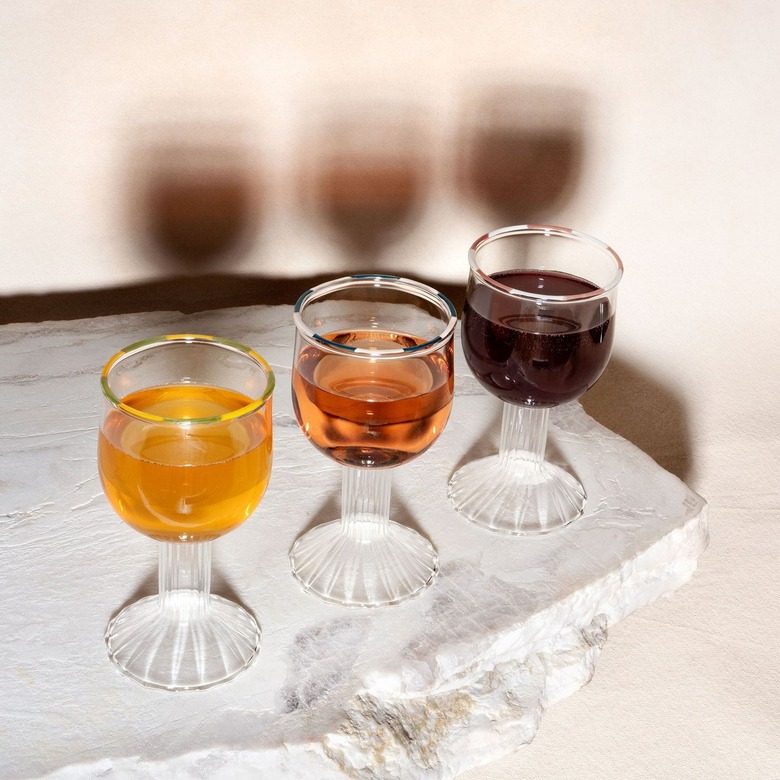 Three kiddish cups lined up on a marble slab.