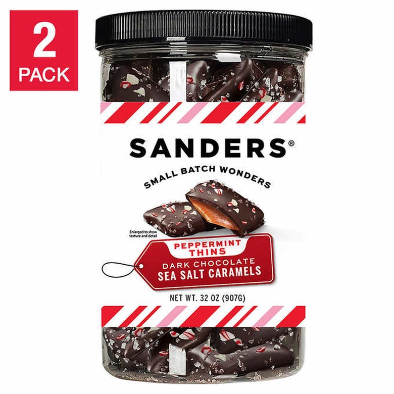 A clear plastic jar filled with dark chocolate sea salt caramels. The label reads 