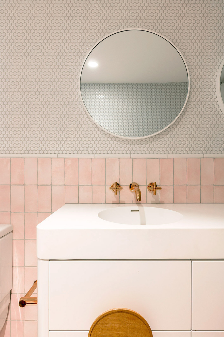 bathroom with pink tile wainscot and round penny tile