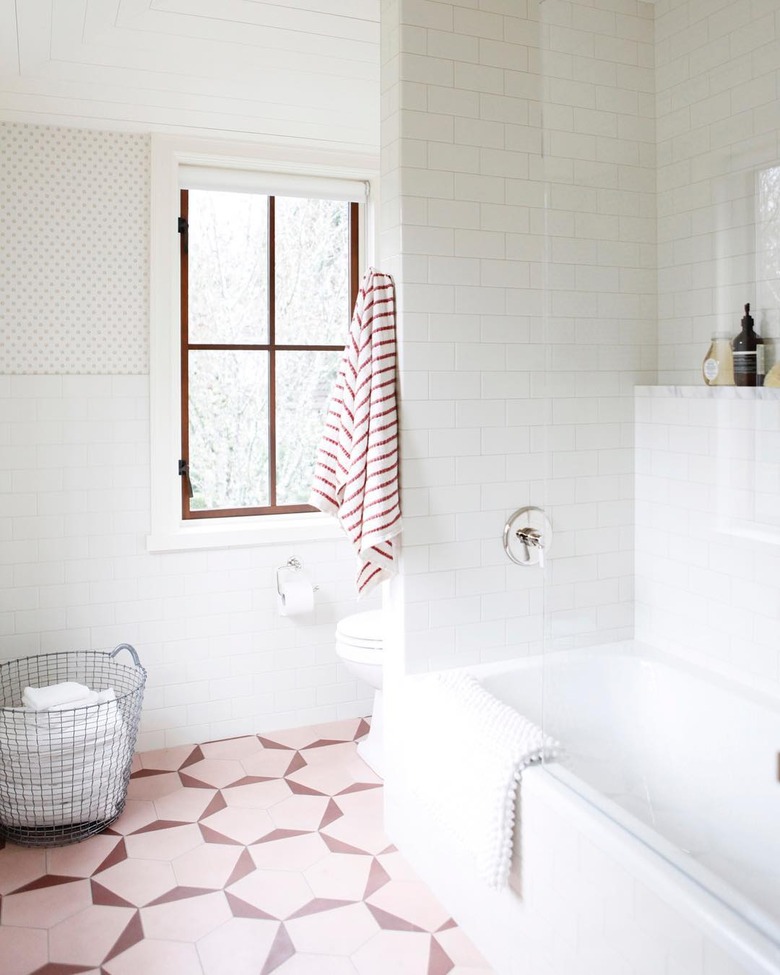 A bathroom with pink tile accents