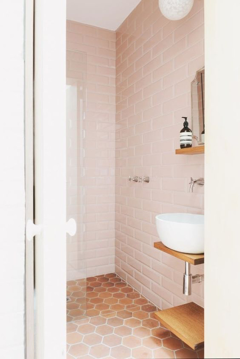 bathroom with pink subway tile and floating vessel sink