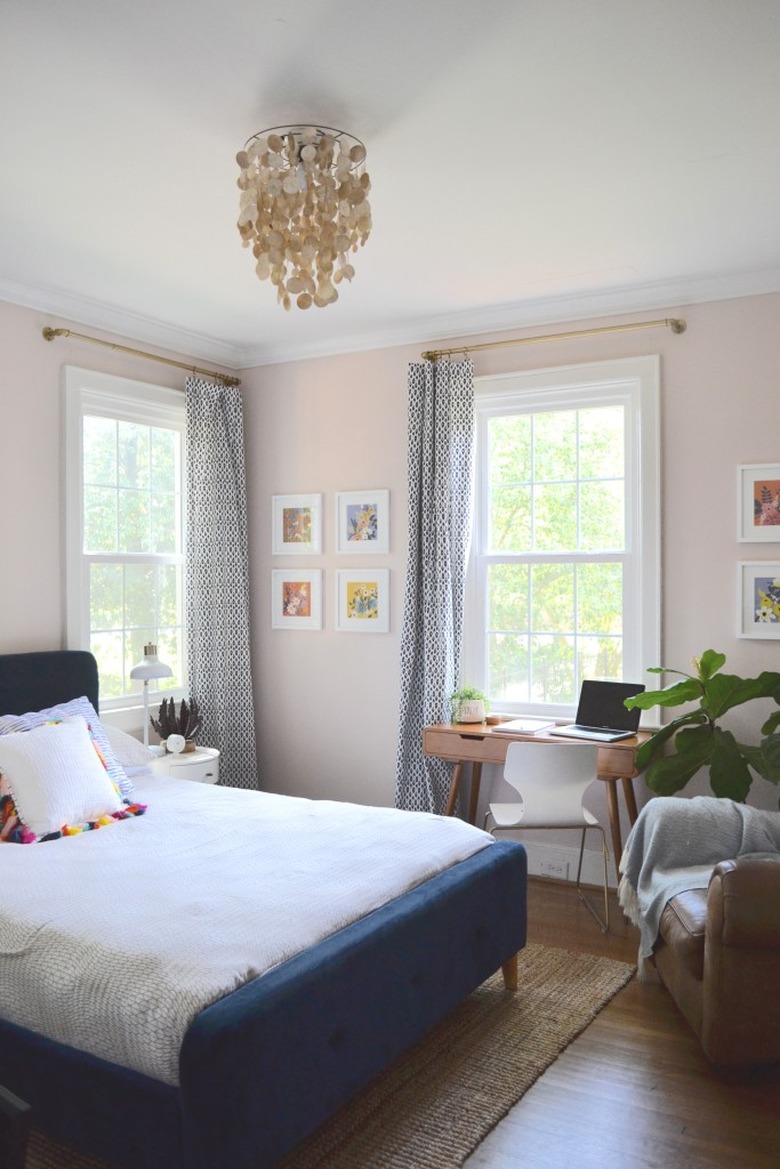 light pink bedroom with blue bed and accent chair