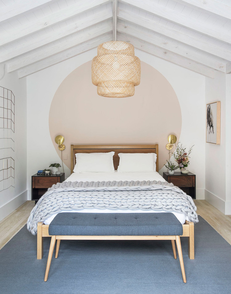 bedroom with pink circle accent wall and Ikea pendant