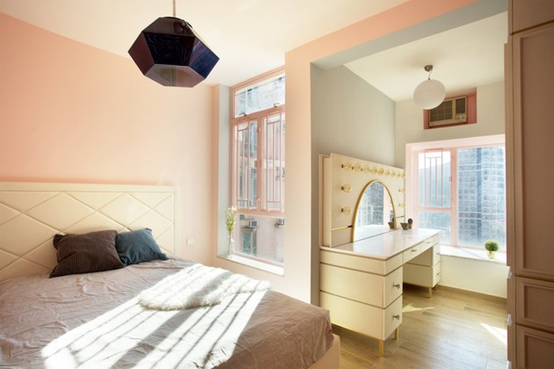 pink bedroom walls with natural light from windows and makeup vanity