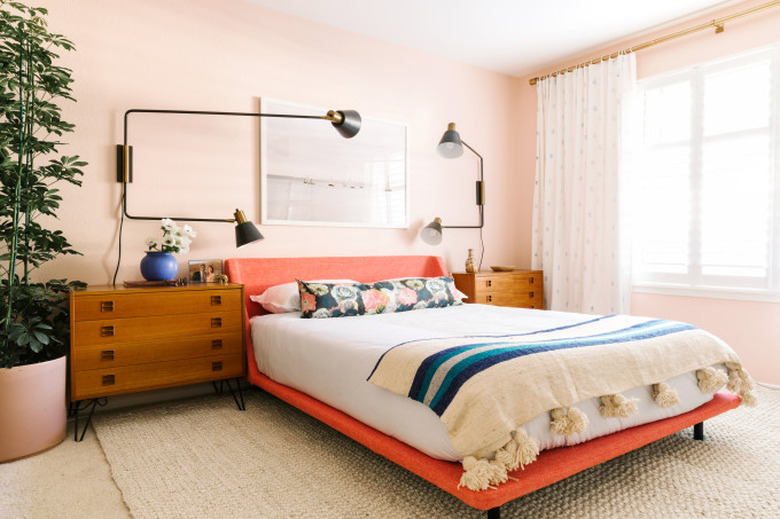 pink bedroom with coral bed and modern wall sconces