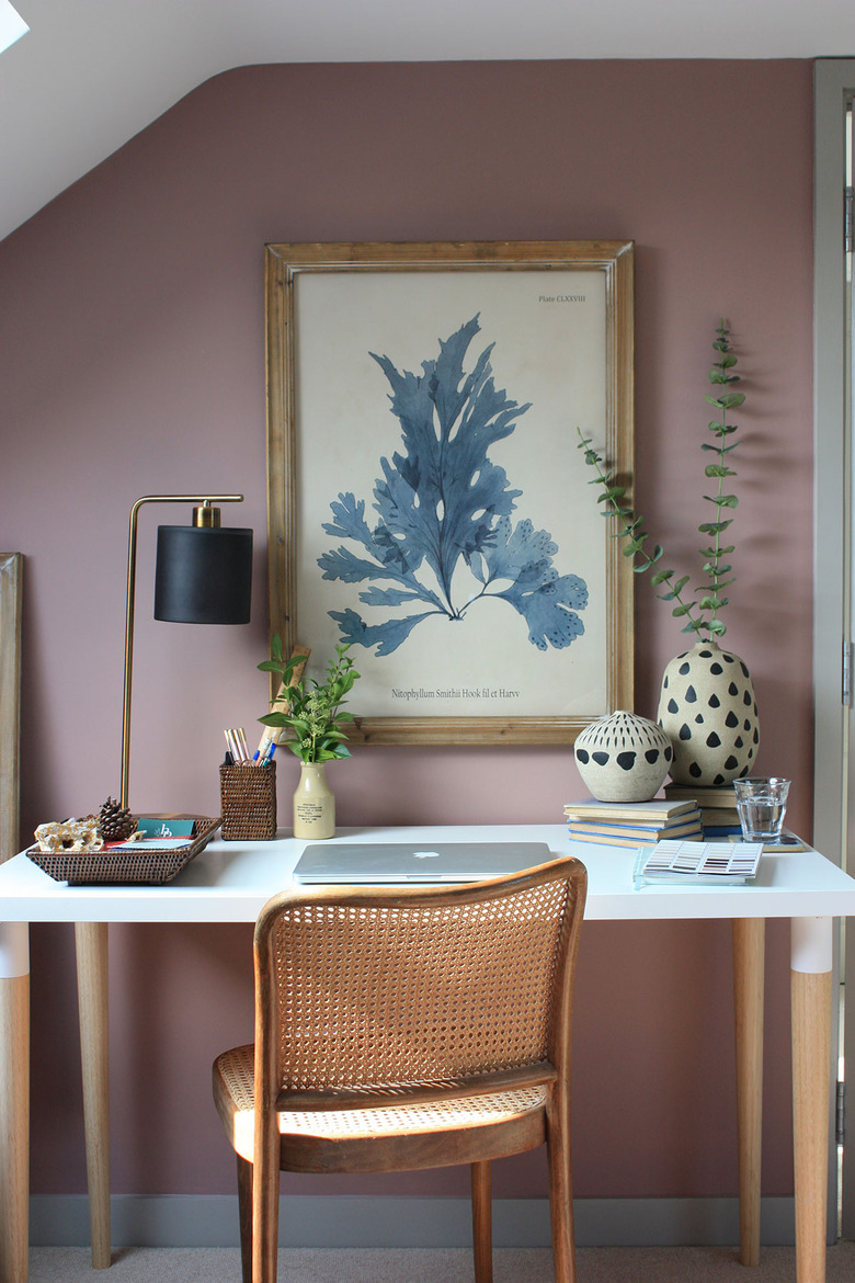 dark pink and purple walls in a home office with cane chair