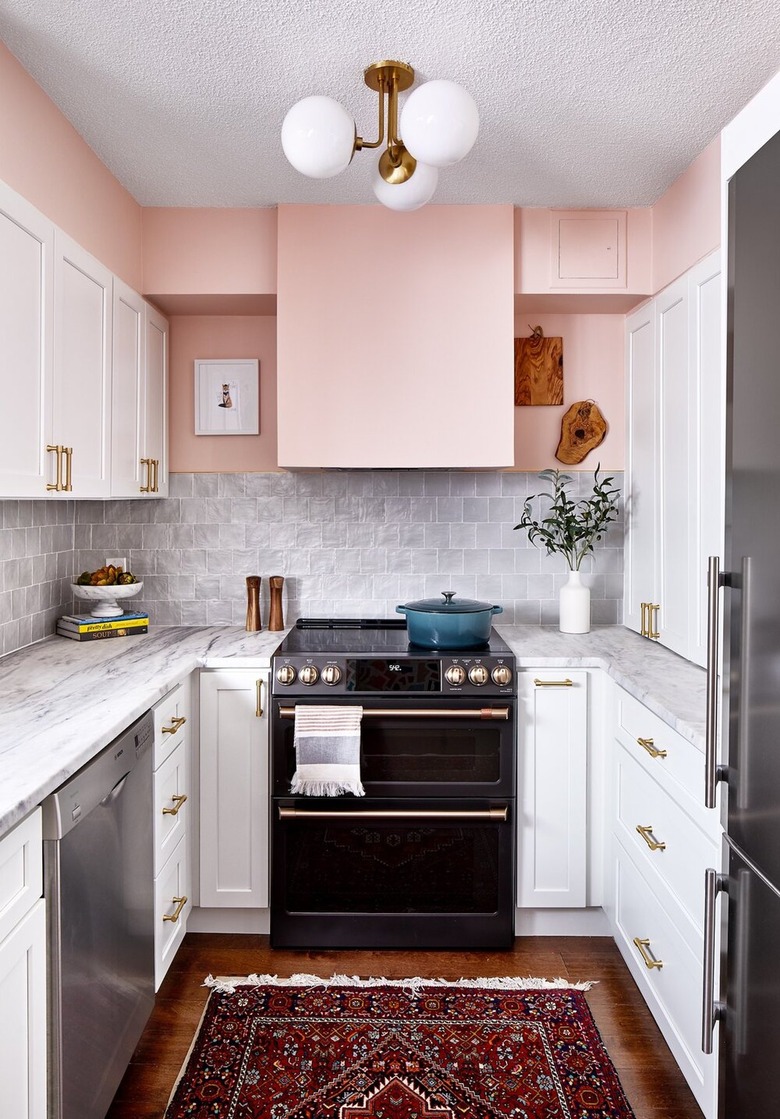 modern kitchen with pink walls and white cabinets