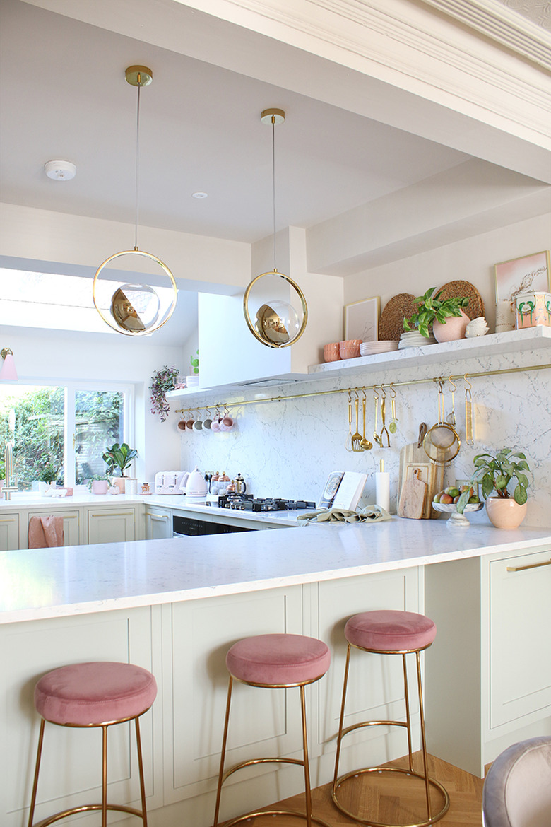 white kitchen with pink stools and open shelves