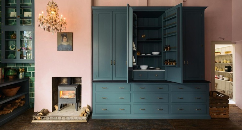 pink kitchen with blue cabinets and crystal chandelier