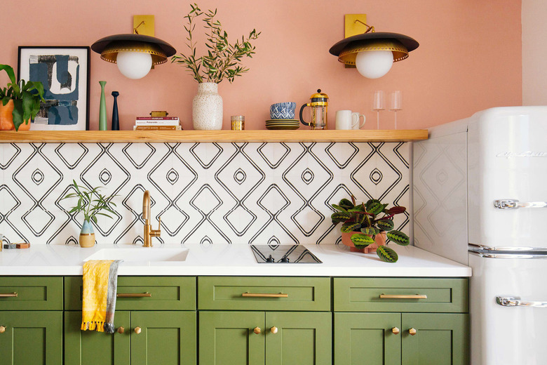 colorful kitchen with pink walls, green cabinets, and patterned backsplash