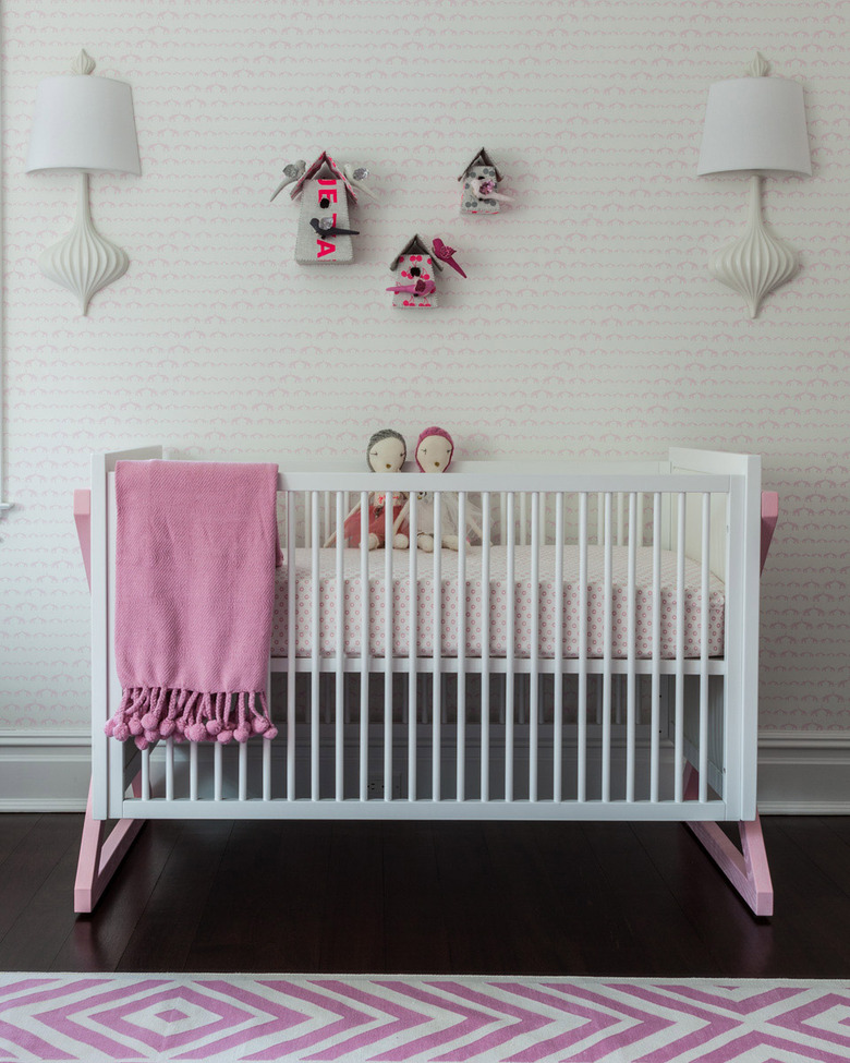 pink nursery idea with white crib and patterned wallpaper