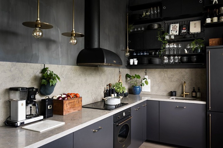 Dark kitchen with dark plaster walls and beige stone backsplash.