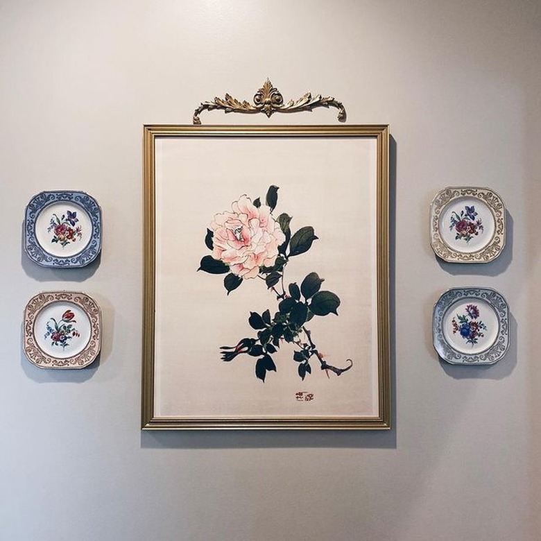 rose painting surrounded by small floral plates