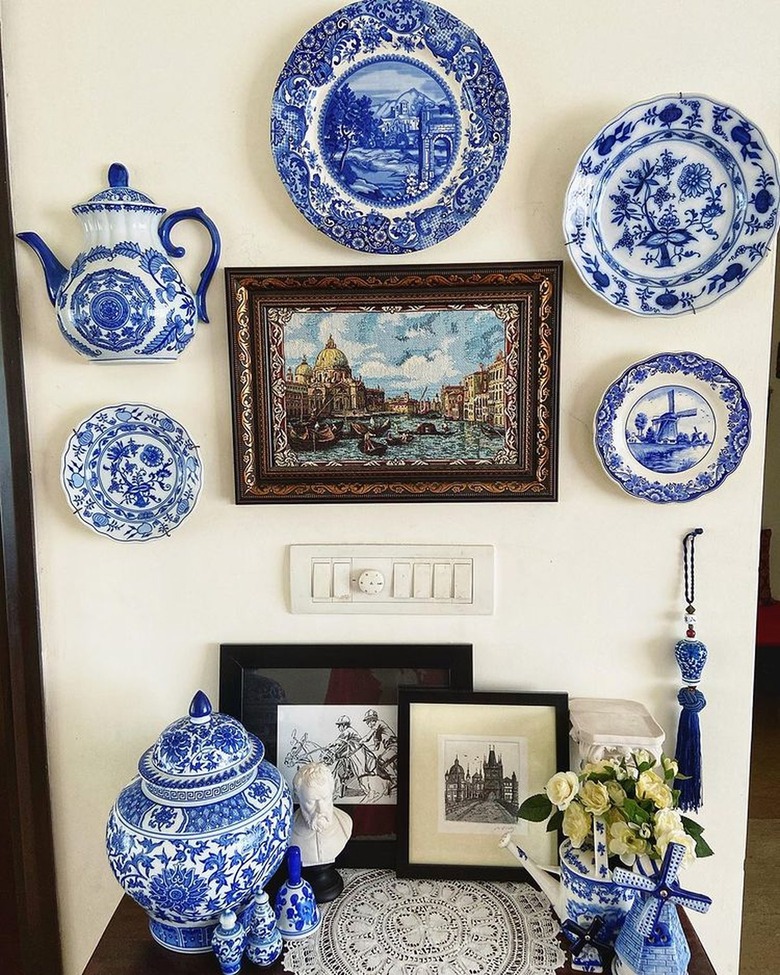 blue and white plates on wall next to decor table