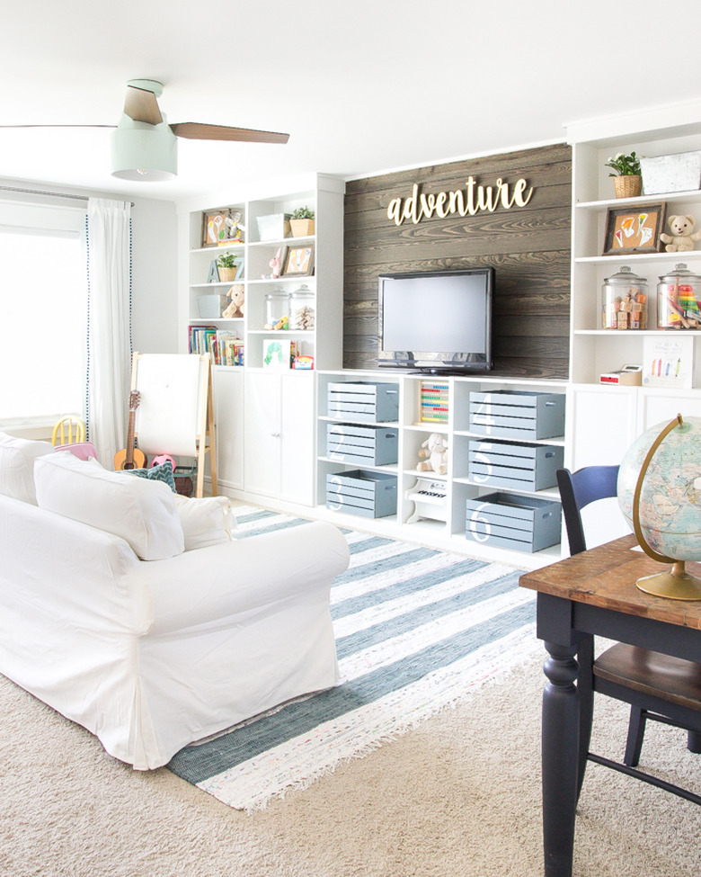 blue and white playroom storage idea with painted crates for concealed storage