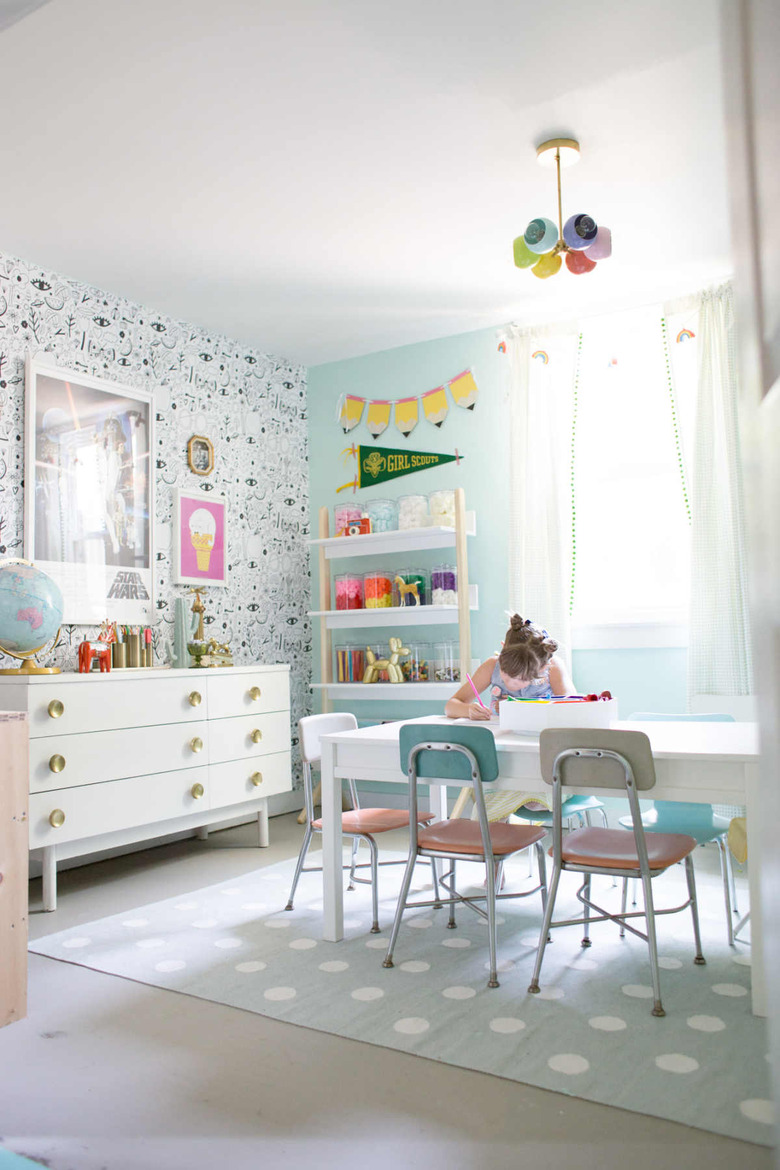 Vintage-inspired playroom storage idea with aqua walls and patterned wallpaper