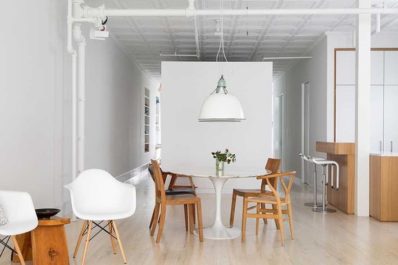 A dining area was arranged using a lot of the client's previous furnishings, including a Saarinen Tulip Table, a hanging light reclaimed from the Plaza Hotel, and a mix of dining room chairs.