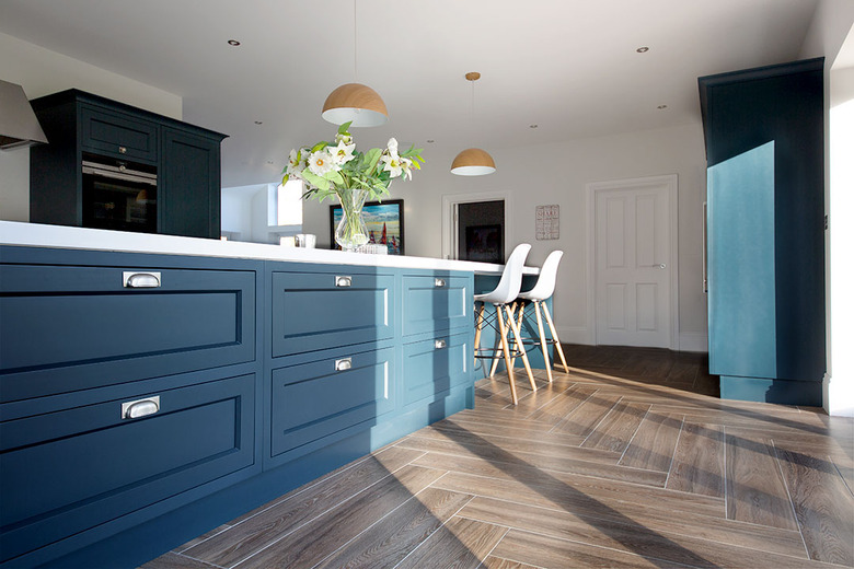 kitchen space with blue cabinets and dark porcelain tile in dark hardwood style