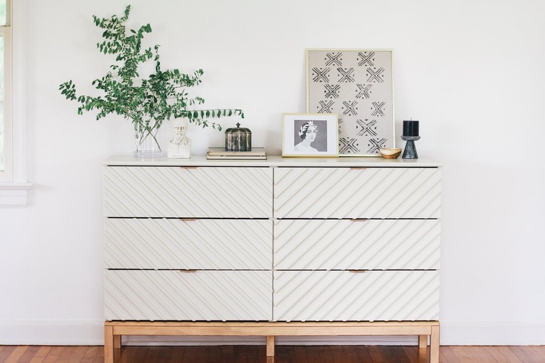 White wood IKEA dresser with plant on wood floor