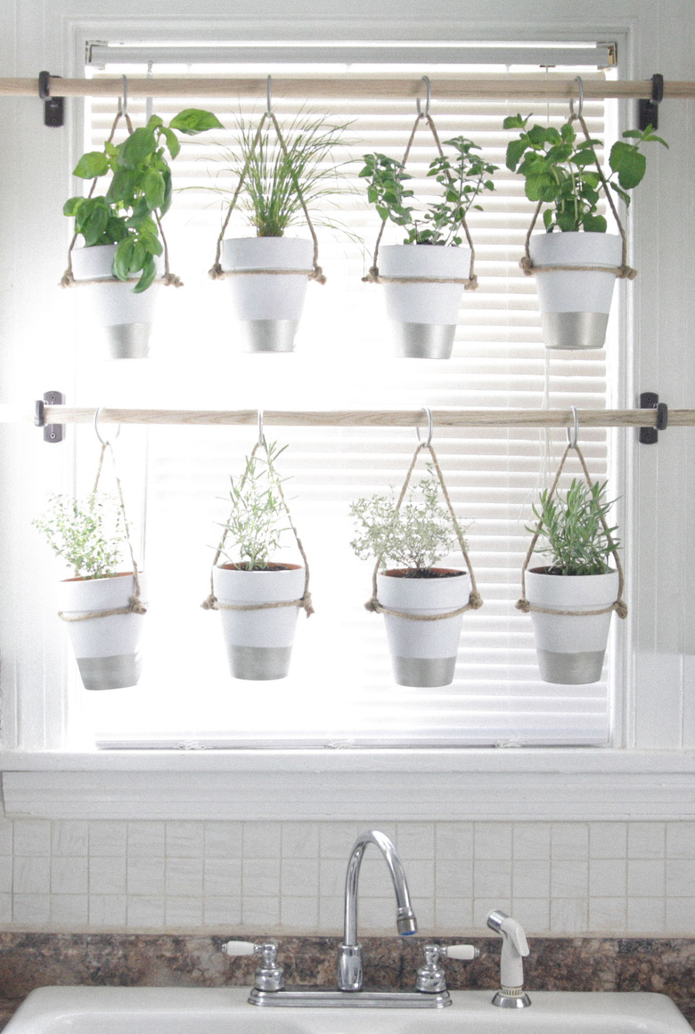 kitchen window idea with hanging herb garden on wooden curtain rods in kitchen window